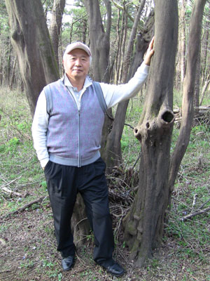 Ilchi Lee next to tree with three holes