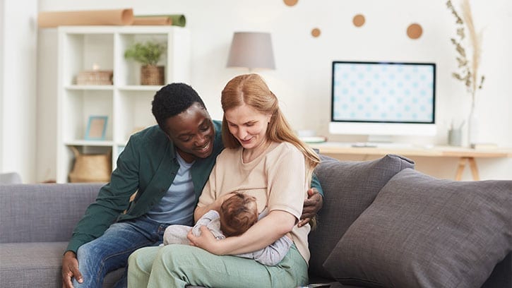 parents with infant on a couch in a living room