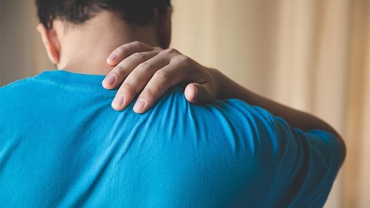 man pressing into his back with is fingers (acupressure)