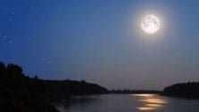 full moon over still lake