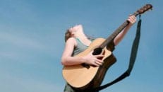 woman playing a guitar - take action