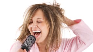 White woman singing into her brush