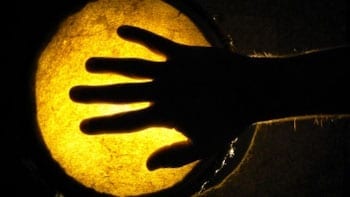 silhouette of hand on glowing drum