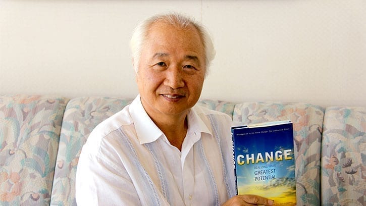 Ilchi Lee holding his book, Change: Realizing Your Greatest Potential