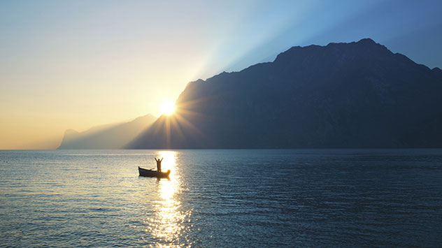 lone canoe on a still lake at sunrise