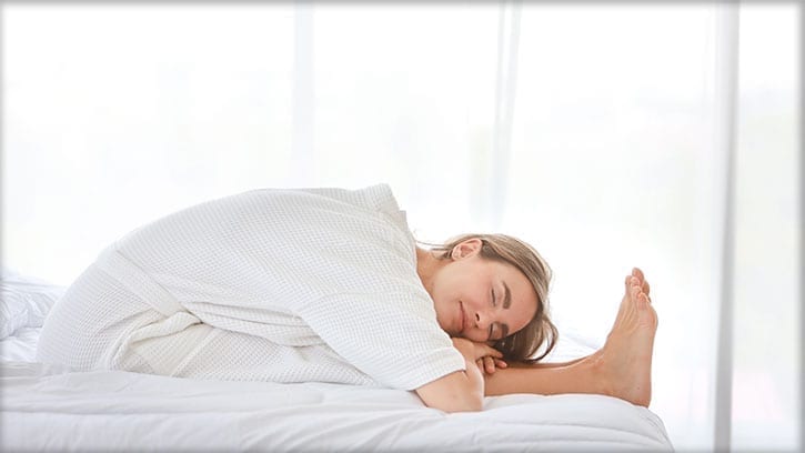 woman stretching on a bed