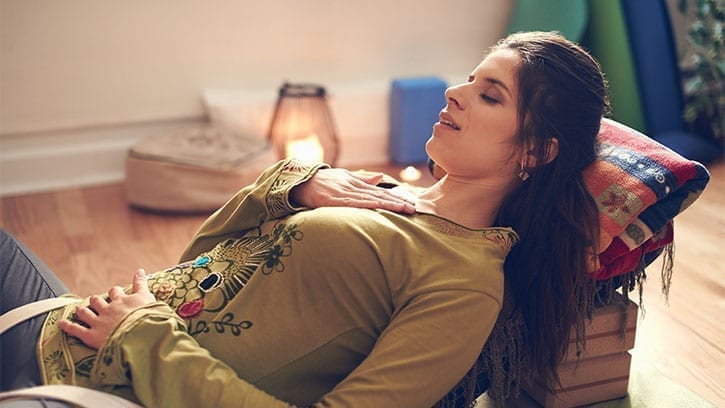 woman meditating while lying on an incline