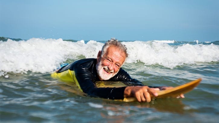 older man surfing the ocean waves