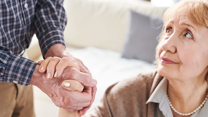 older woman holding hands