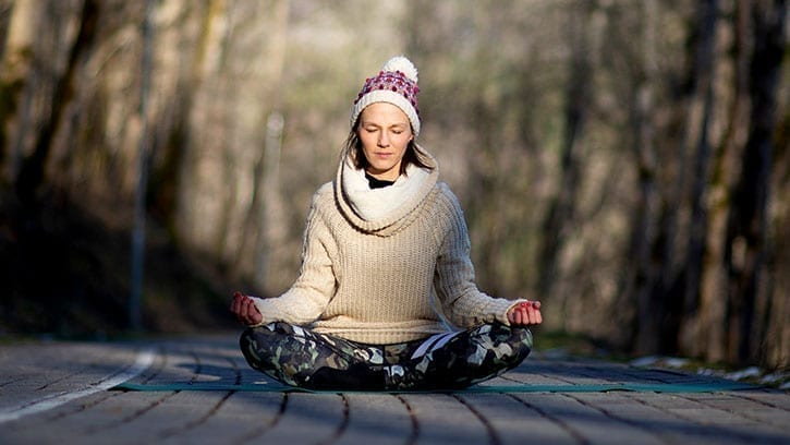 woman meditating in cold woods