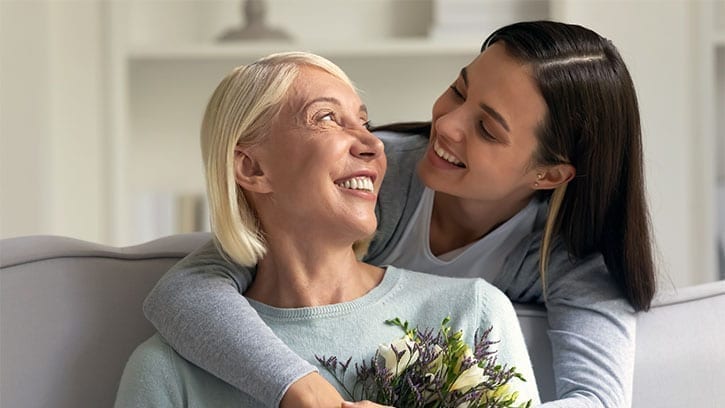 Daughter giving flowers to mother