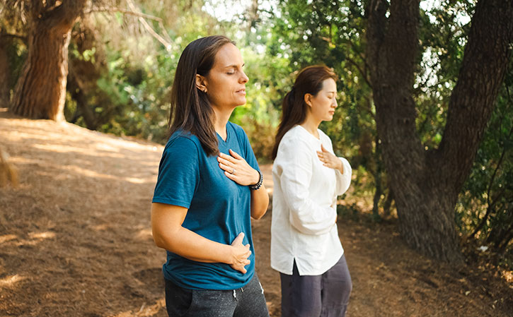 Dana and a Brain Education instructor practicing outdoor meditation based on Water Up, Fire Down energy principle