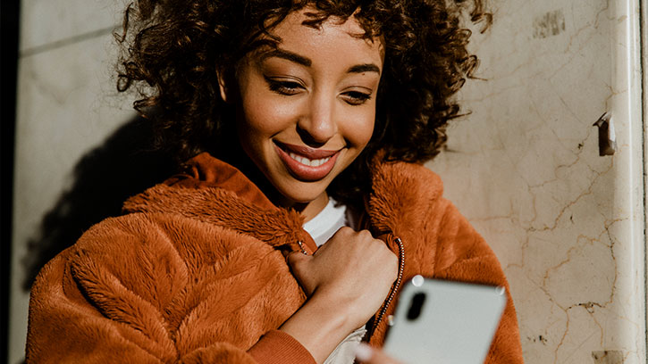 young black woman looking at her smartphone