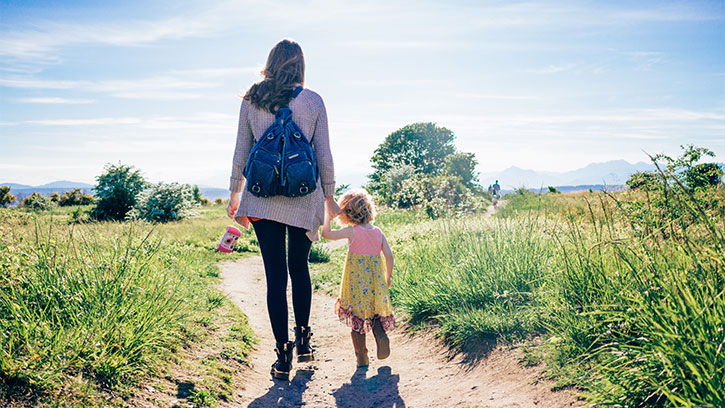 mother and daughter walking on a dirt path