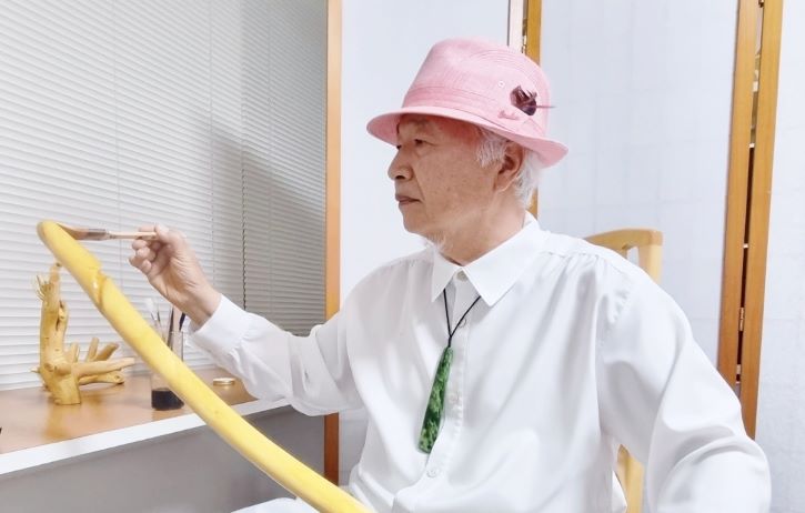 Ilchi Lee painting wood stick with hwangchil lacquer