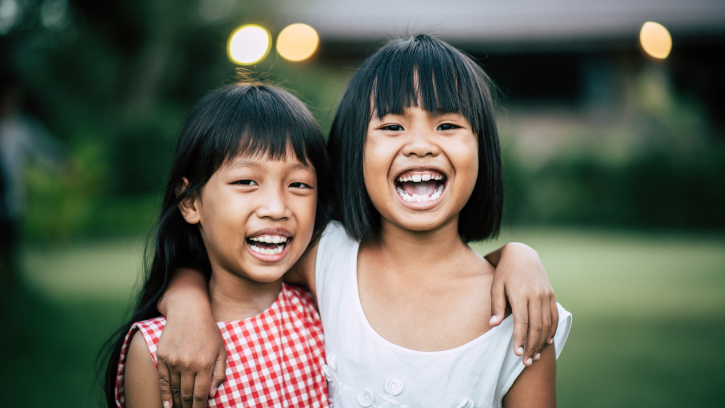 Two little girls friends playing funny in the park