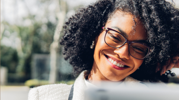 Close up view of a happy businesswoman watching good news on her digital tablet outdoor.