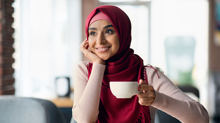 dreamy middle eastern woman smiling at a coffee shop