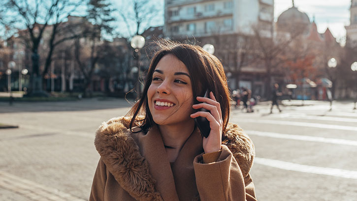 young professional woman talking on her phone in an empty city square