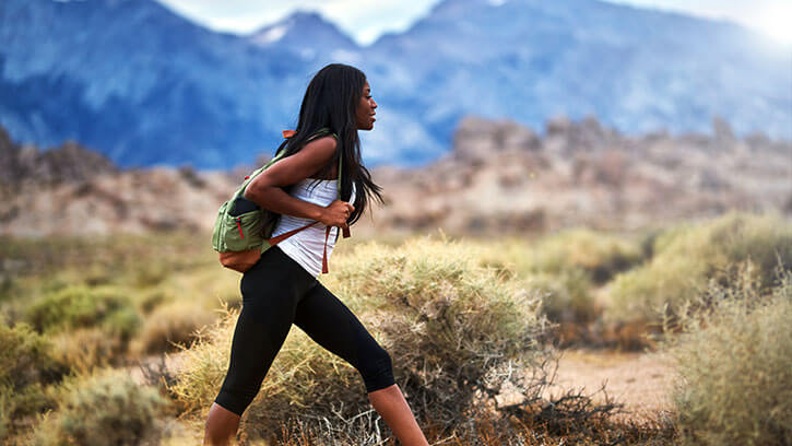 fit african american woman hiking through alabama hills park in california