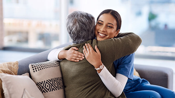 Young and older woman hugging.