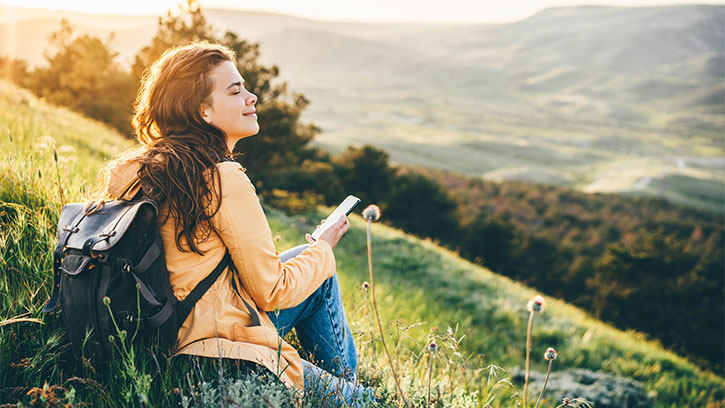 young woman sitting on a grassy hill