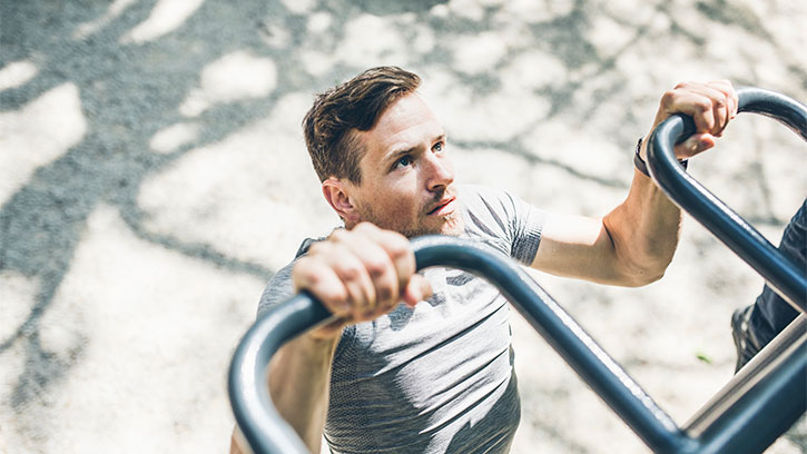 man doing pullups in the park