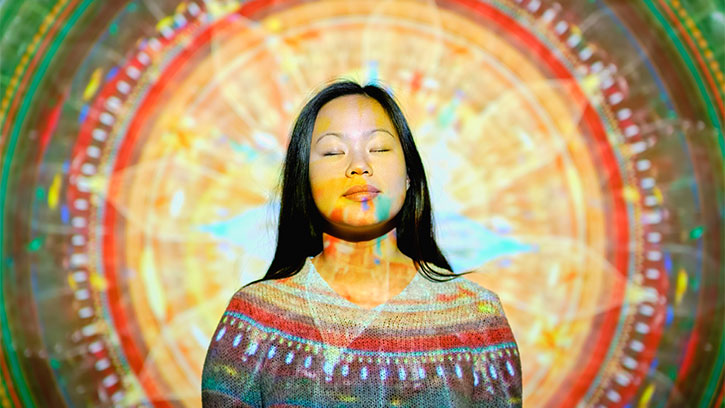 Young Asian woman with mandala projected on her upper body and head