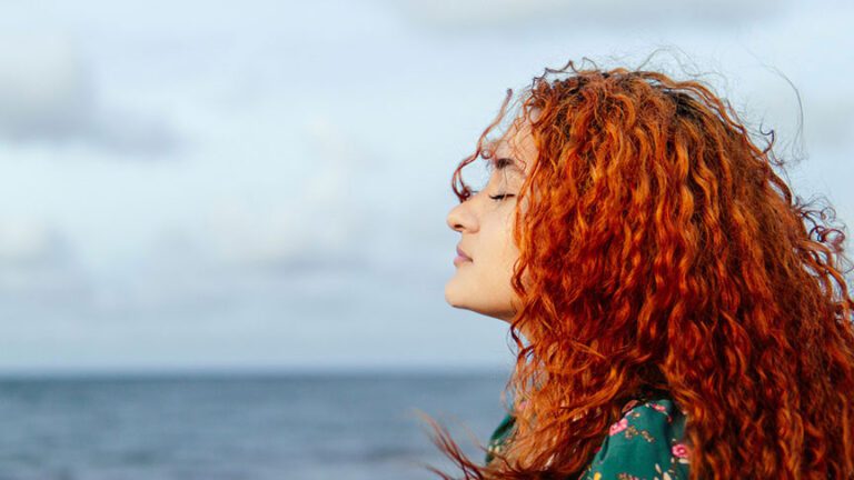 woman at the ocean breathing fresh air
