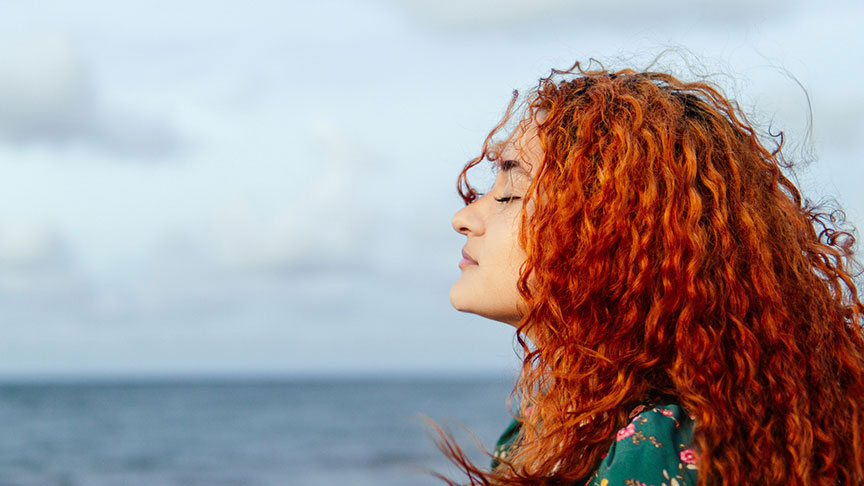 woman at the ocean breathing fresh air