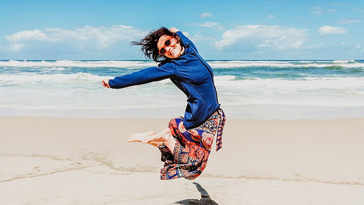 girl jumping in the air on the beach