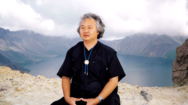 Ilchi Lee meditating on a mountain