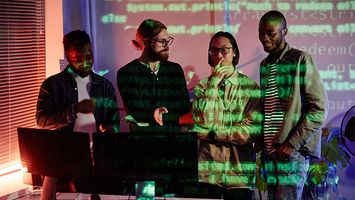 group of multicultural people in an office with green electronic writing on a transparent screen