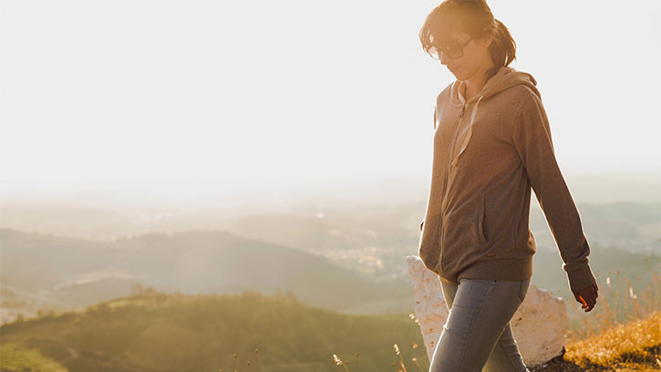 woman walking in brown misty hills