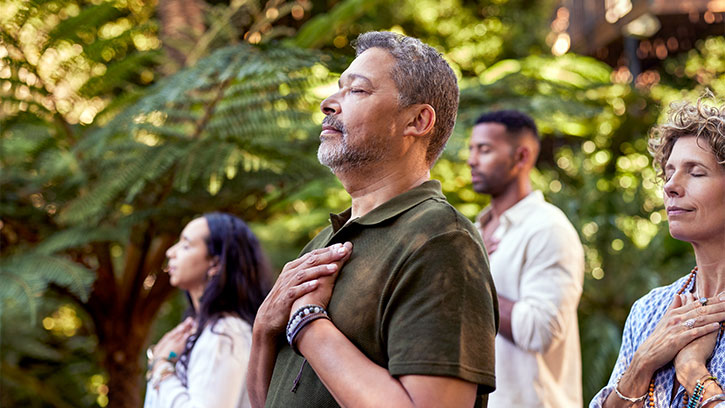People Meditating Outdoors Among Green Trees
