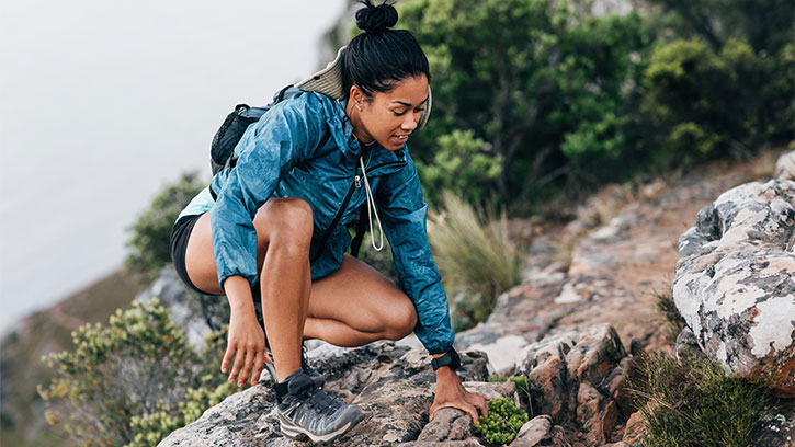 woman climbing rocky mountain