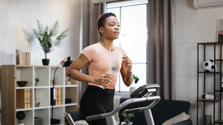 woman exercises on treadmill in living room