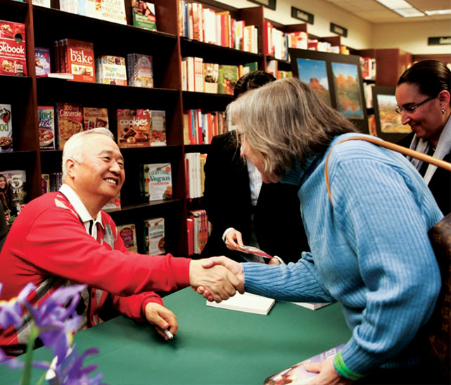 Ilchi Lee greeting a reader at a bookstore event