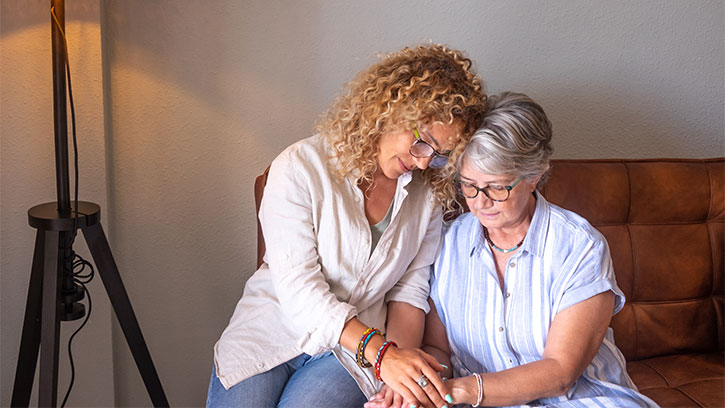 Loving Woman Comforts Her Gray Haired Senior Mother